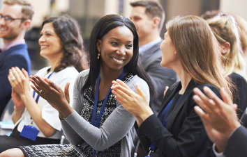 two women facing with each other while claping their hands